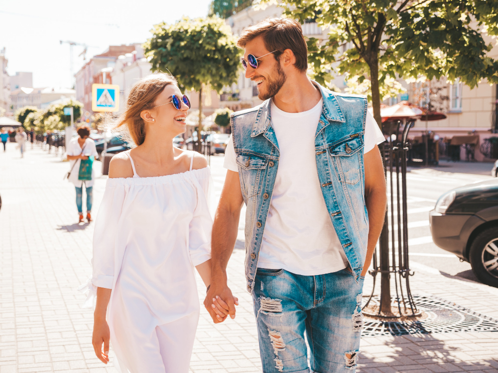 A smiling couple walking together in a sunny Toronto neighbourhood